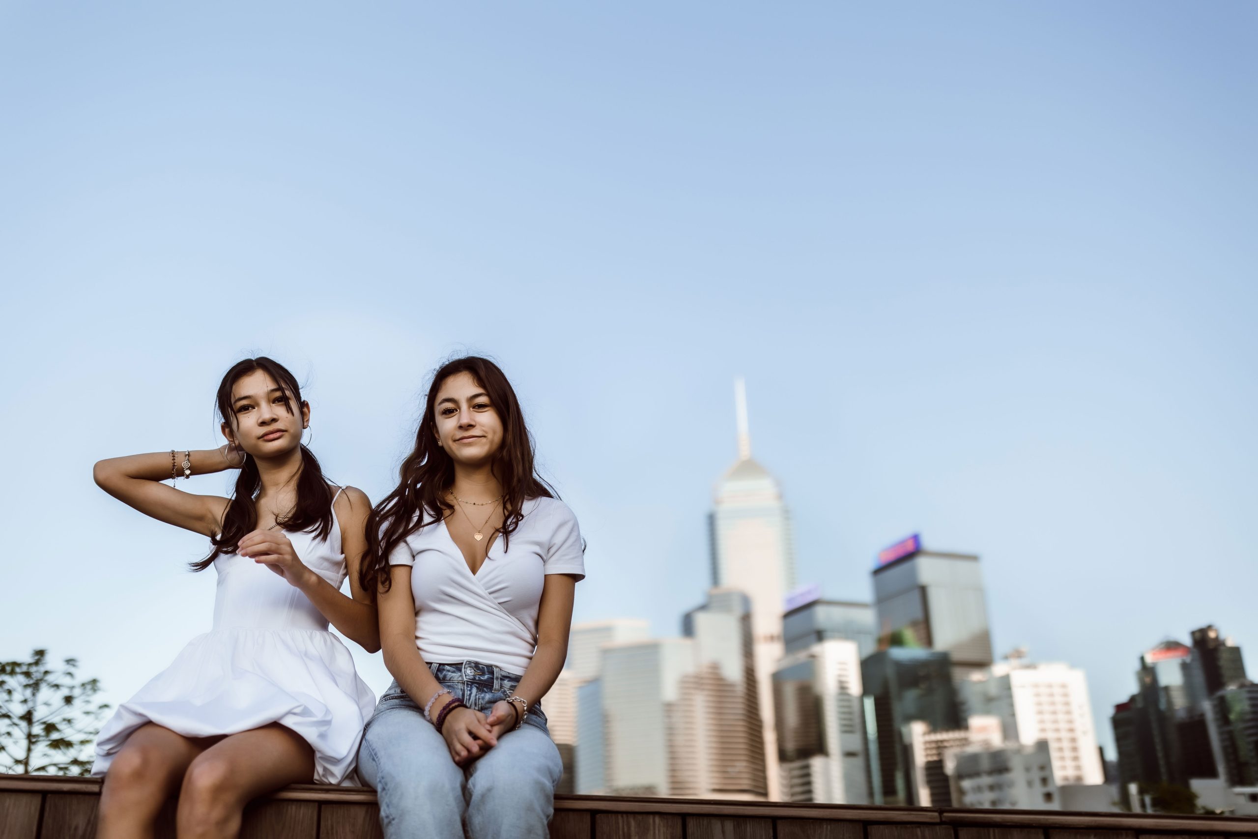 Two young ladies posing near the Hong Kong skyline