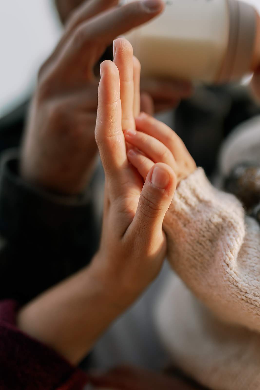 Close-up of child holding parent’s hand during family photo session in Sai Kung