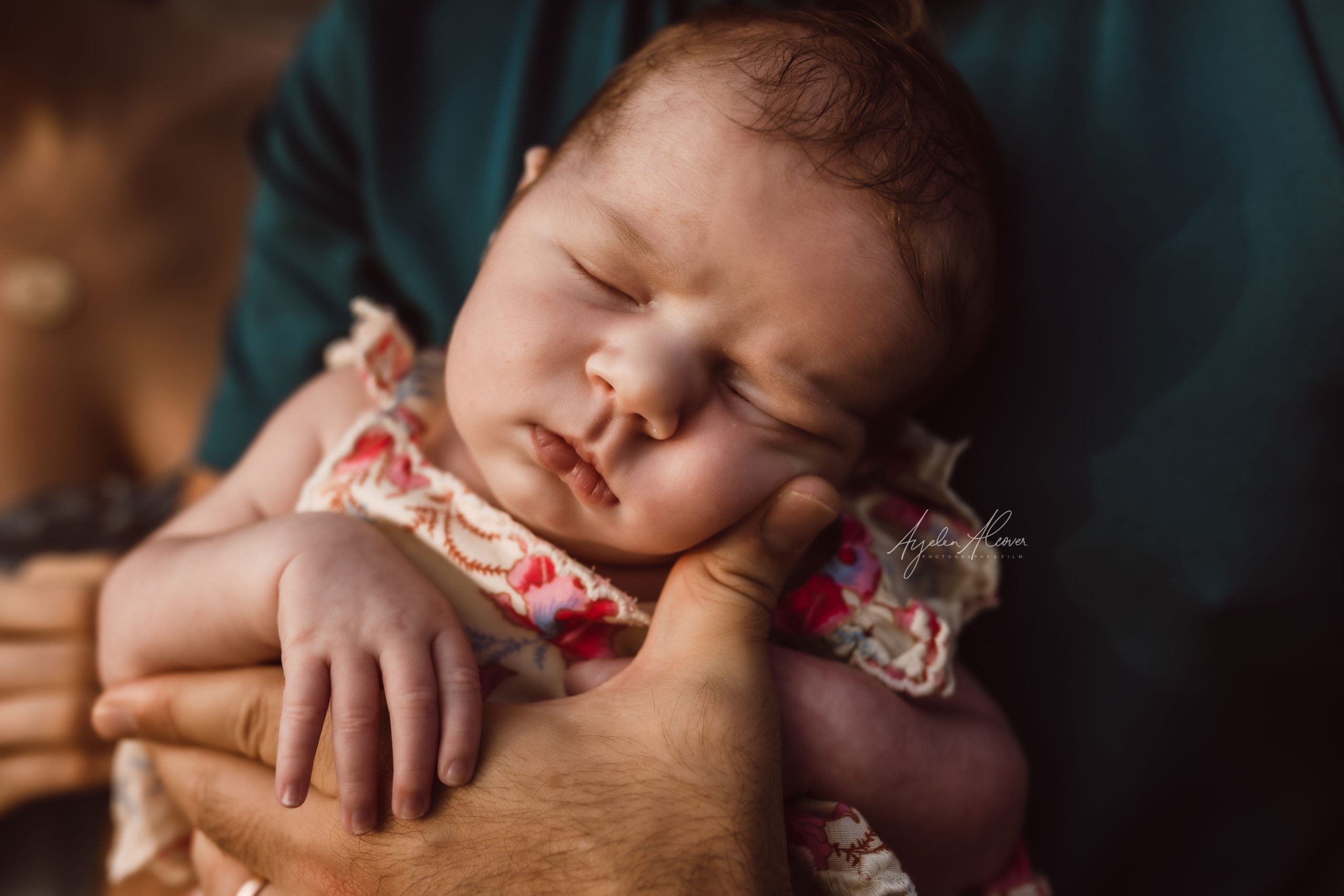 Close up portrait of gorgeous baby girl sleeping peacefully on his dad's arms