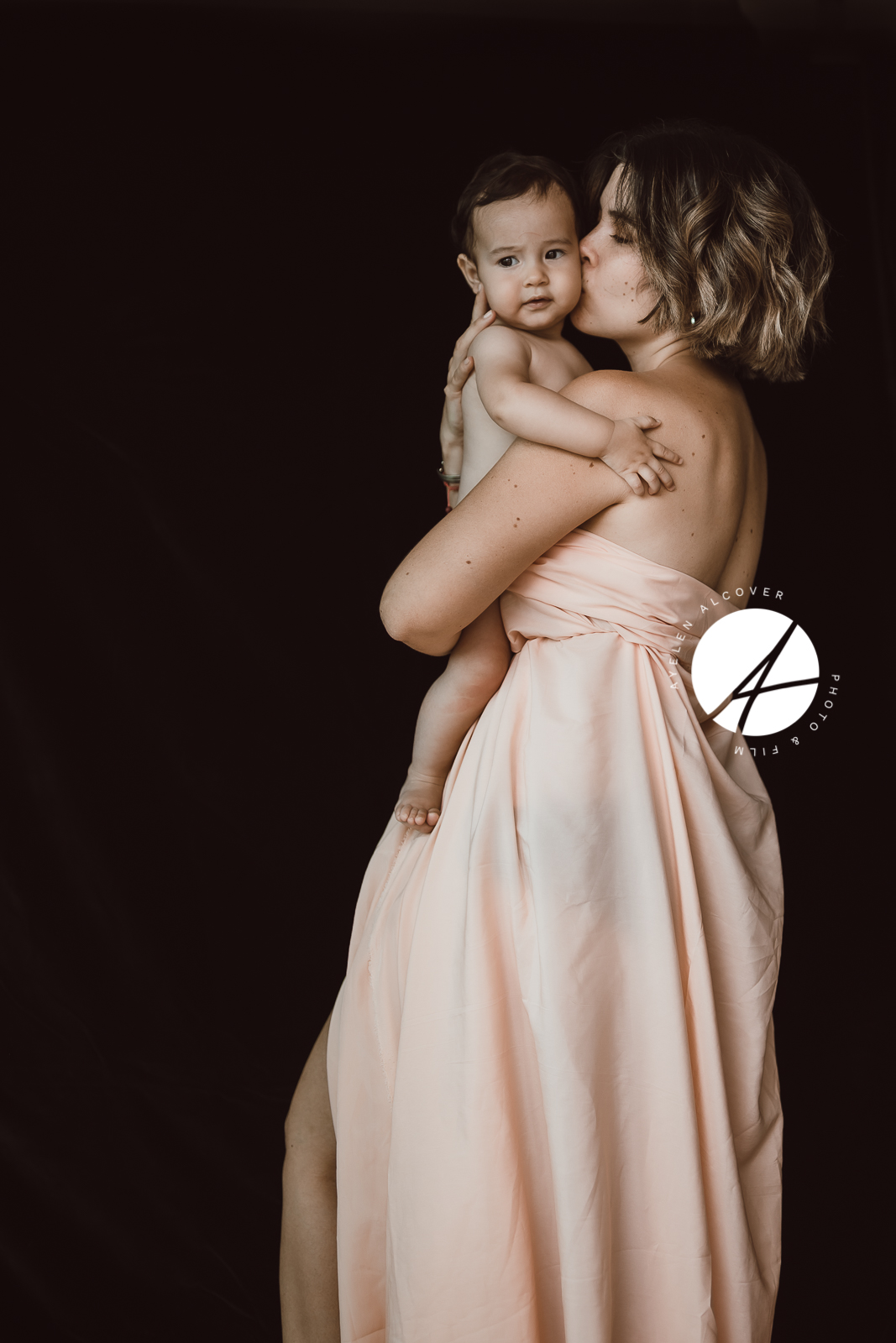 Mother kissing her baby boy on the cheek