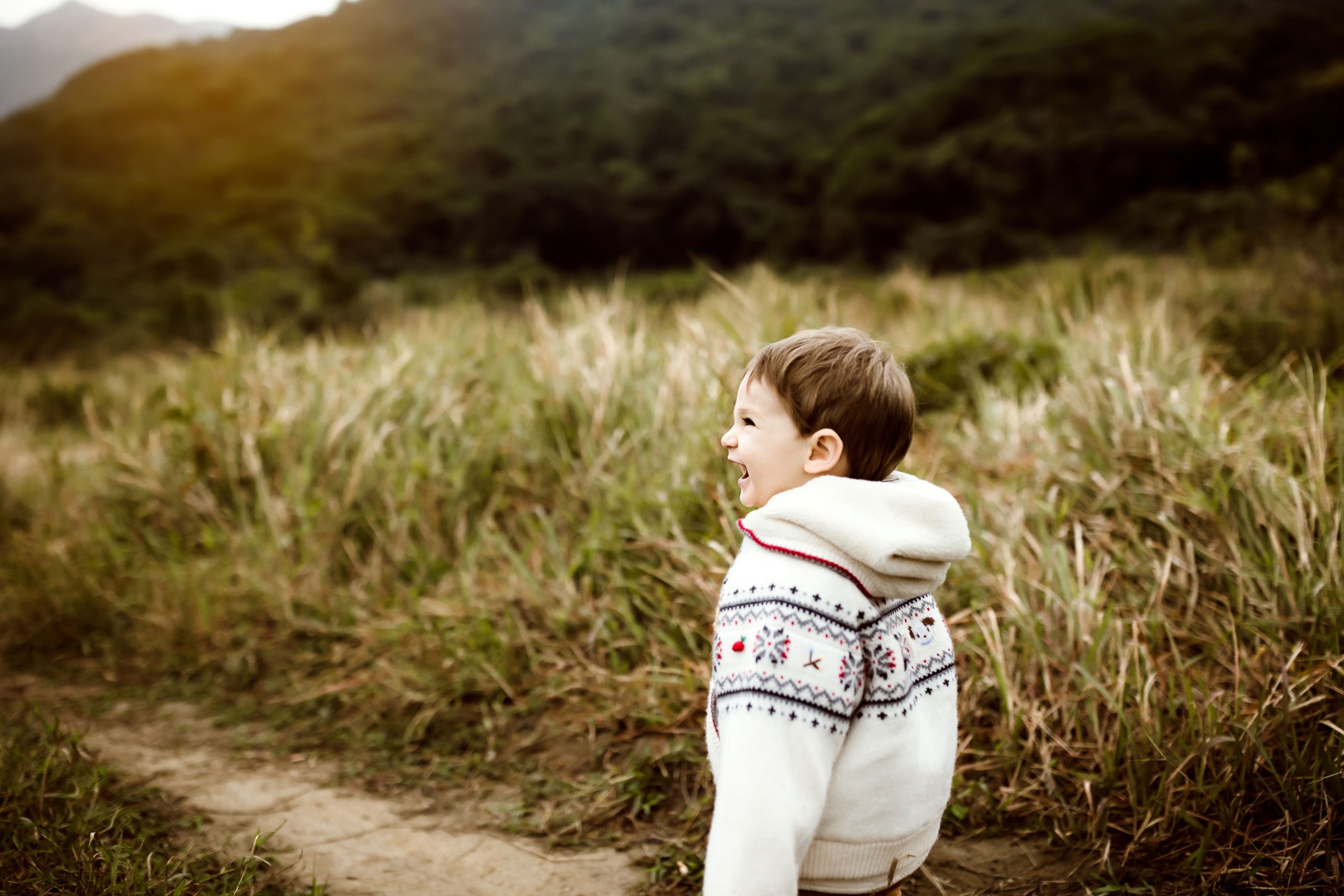 Baby boy smiling while walking on the mountains